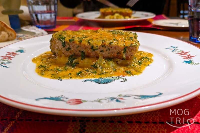 フランス料理店mondo（モンド）のメイン料理「恵庭産 “米豚三源とん” のロースト シャルキュティエール風」がテーブルに置かれている