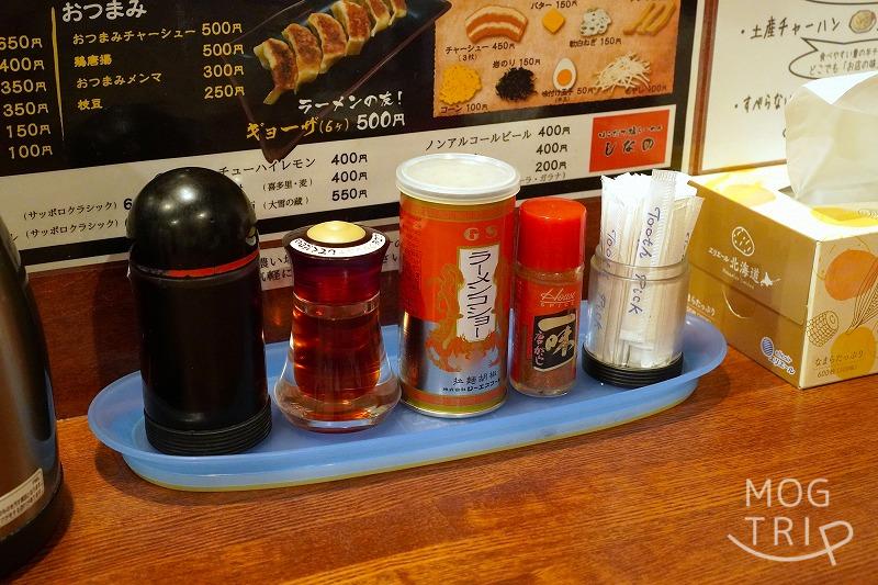 「函館塩ラーメン しなの」のテーブルに、胡椒やラー油、つまようじなどが置かれている