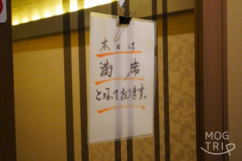 和菜酒房おりべの入口ドアに満席の案内が貼られている