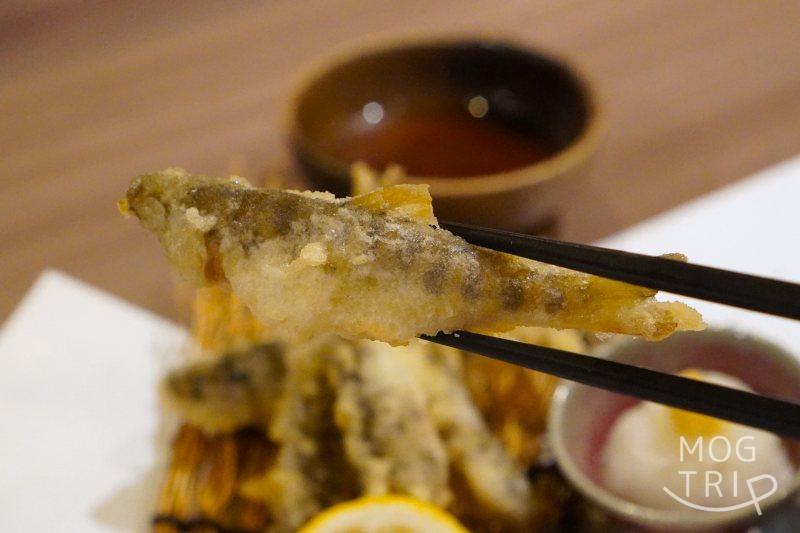 和菜酒房おりべのやまべの天ぷらを箸で持ち上げている様子