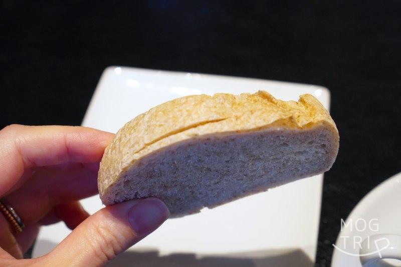 「P’tit salé（プティ サレ）」の自家製パンを手に持っている様子