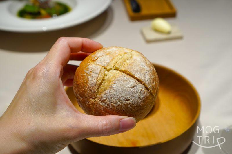 ロワゾーパーマツナガの「自家製パン」を手に持っている様子