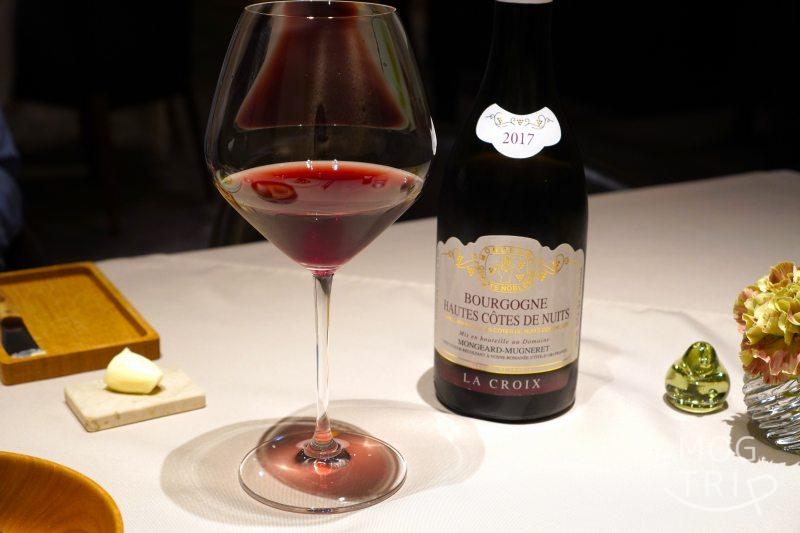 赤ワインのボトルとグラスがテーブルに置かれている
