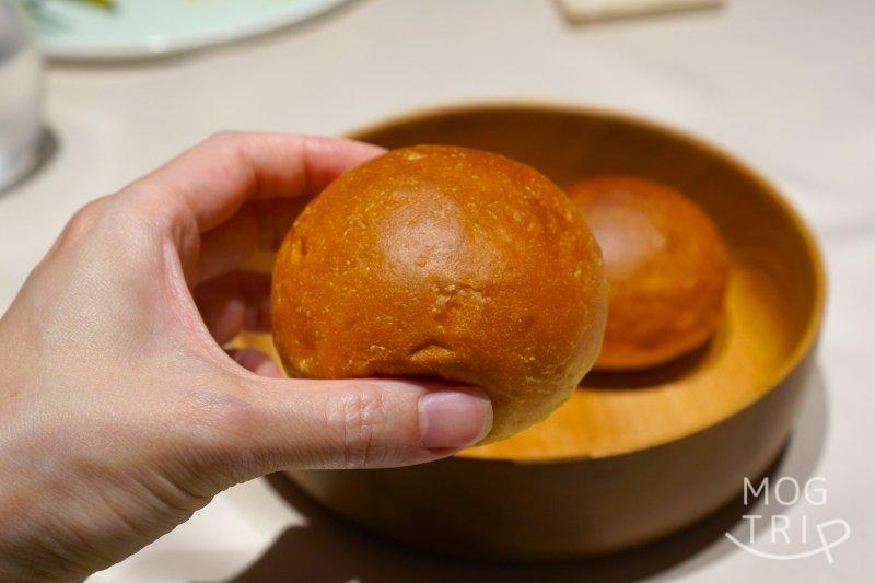 ロワゾーパーマツナガの「牛乳の自家製パン」を手に持っている様子