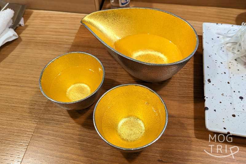 札幌すすきの「鮨処いちい」の日本酒と御猪口がテーブルに置かれている