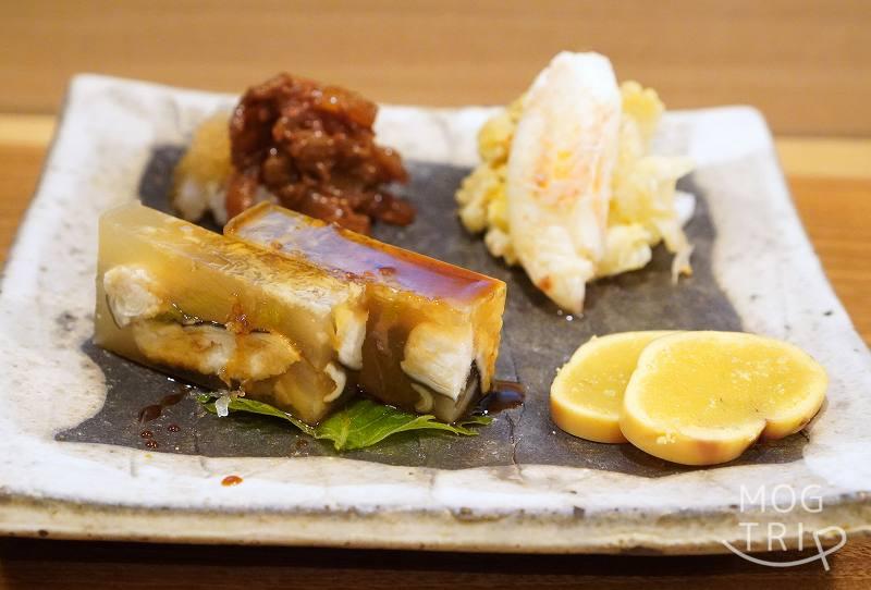 札幌すすきの「鮨処いちい」の小鉢プレートがテーブルに置かれている