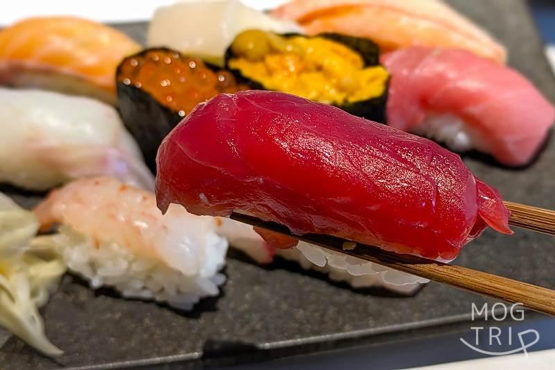 札幌すすきのにある「すしうおいち」握り寿司を箸で持ち上げている様子