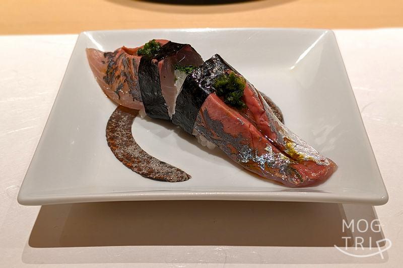 札幌すすきのにある「まる鮨」のアジの握りがテーブルに置かれている