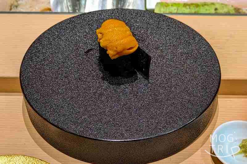 札幌すすきのにある「まる鮨」のうにの握りがテーブルに置かれている
