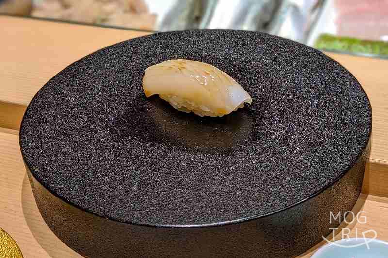 札幌すすきのにある「まる鮨」のすみいかの握りがテーブルに置かれている