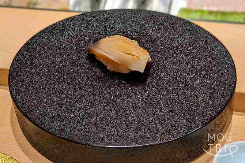 札幌すすきのにある「まる鮨」のホッキの握りがテーブルに置かれている