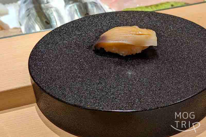 札幌すすきのにある「まる鮨」のホッキの握りがテーブルに置かれている