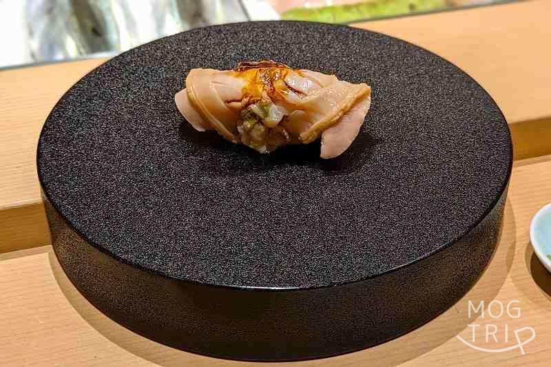札幌すすきのにある「まる鮨」の蛤の握りがテーブルに置かれている