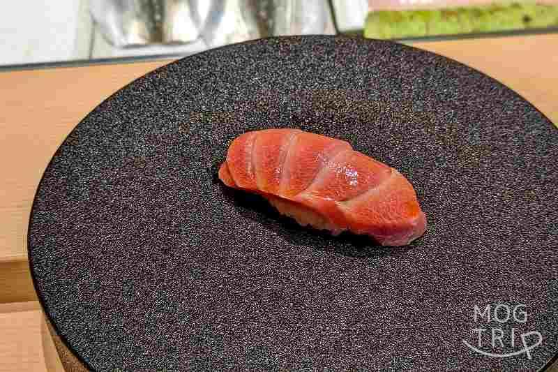 札幌すすきのにある「まる鮨」の大トロの握りがテーブルに置かれている
