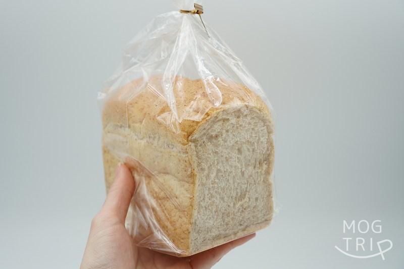 「はるゆたか小麦とゆめちから全粒粉入りのパン」を手に持っている様子