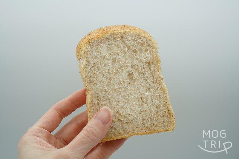 スライスした「はるゆたか小麦とゆめちから全粒粉入りのパン」を手に持っている様子