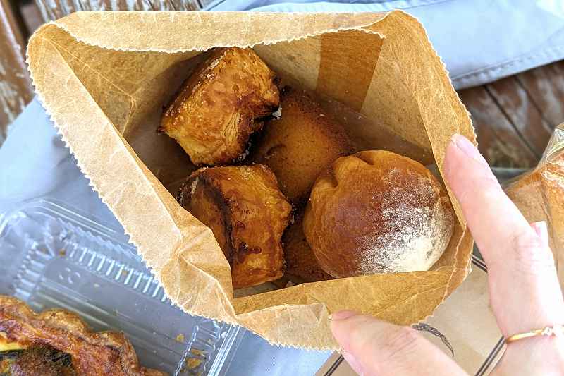札幌「boulangerie yue.
（ブーランジェリーユエ）」の袋入り焼き菓子をあけている様子
